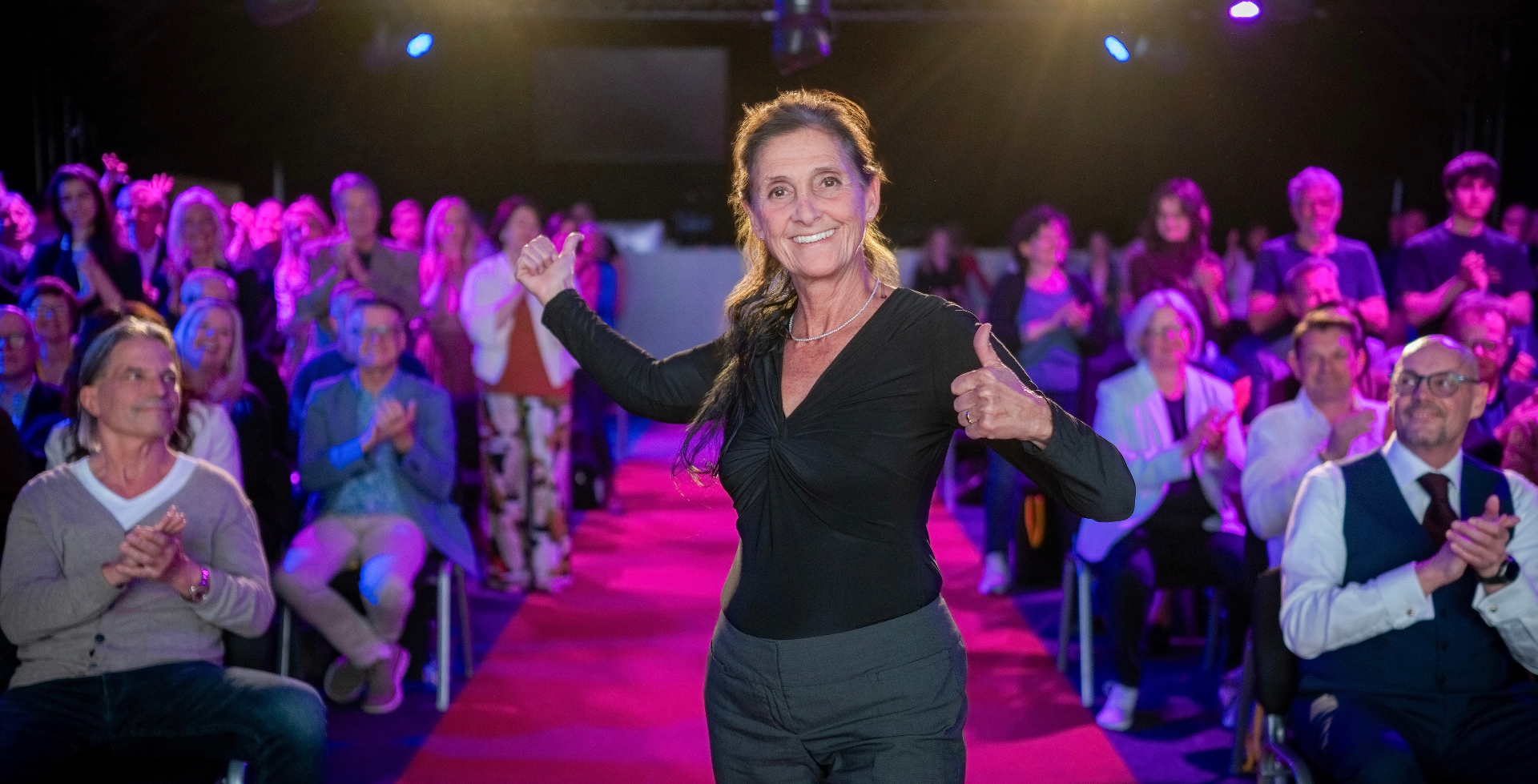 Roswitha Sion auf der Bühne, applaudierendes Publikum